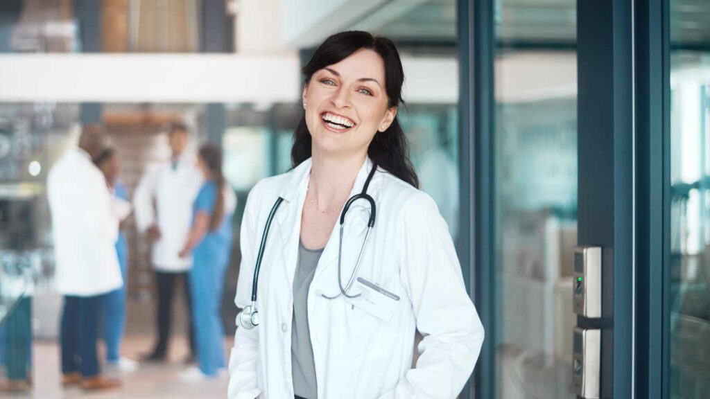 Lächelnde Ärztin repräsentiert medizinische Expert:innen und Fachkräfte im Gesundheits- und Pharmabereich.