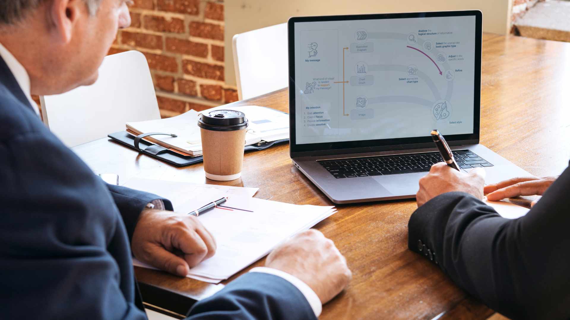 Zwei Personen erstellen gemeinsam eine Präsentation am Laptop, um eine Rede optimal zu unterstützen.
