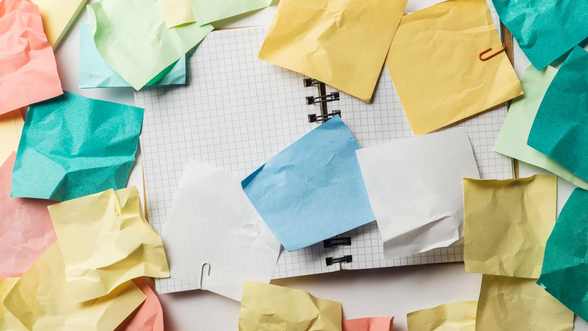 Bunte Notizzettel auf kariertem Block – Kreatives Brainstorming für eine überzeugende Vortragsstruktur